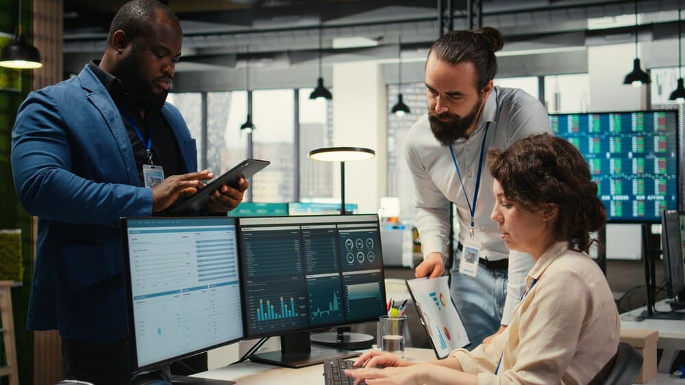 Equipe de especialistas analisando gráficos e alocação de recursos online