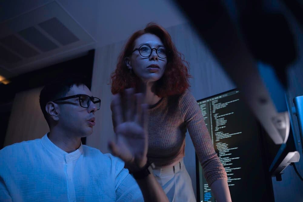 Dois desenvolvedores de software colaborando em revisão de código