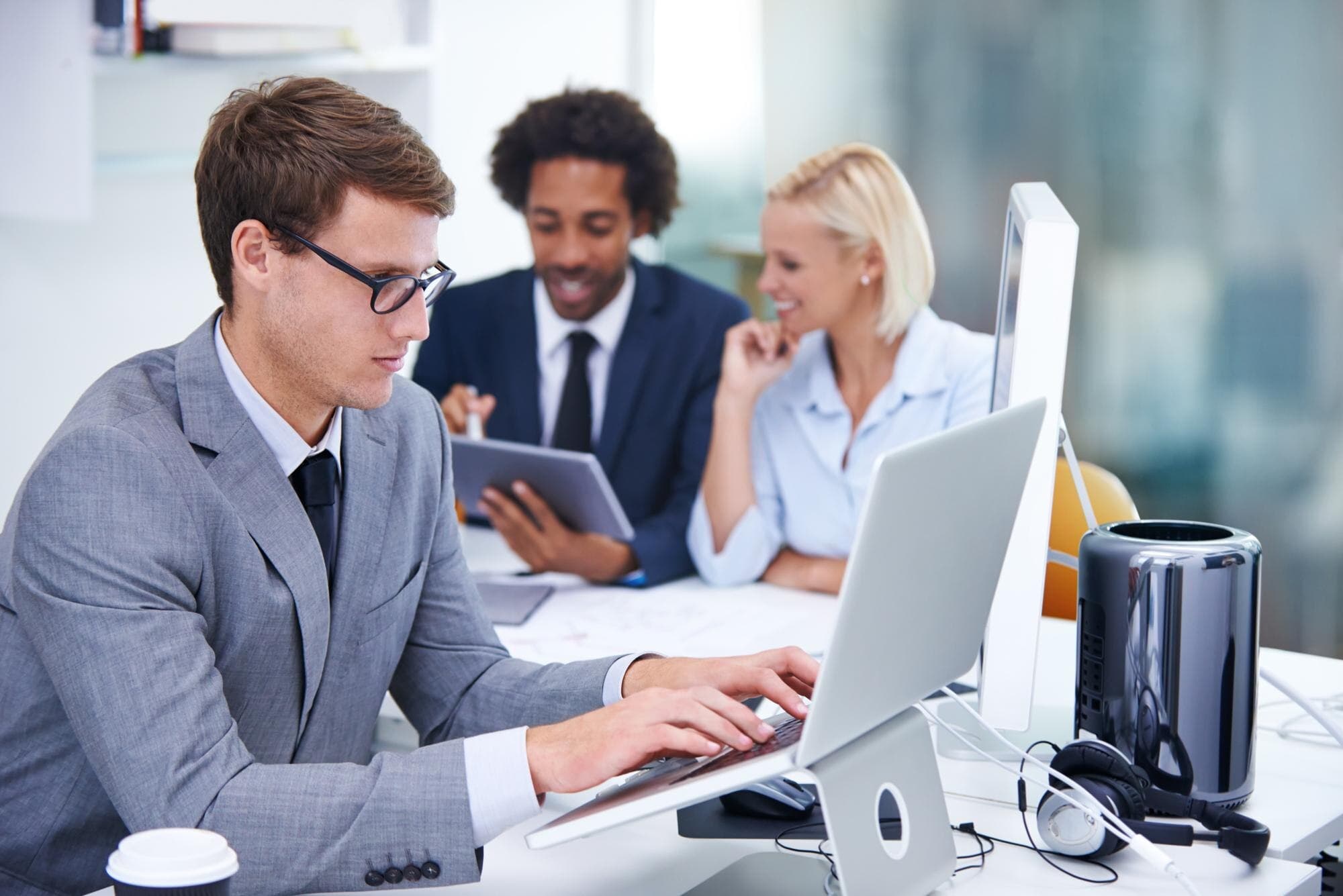 Equipe em reunião analisando o conteúdo de um notebook