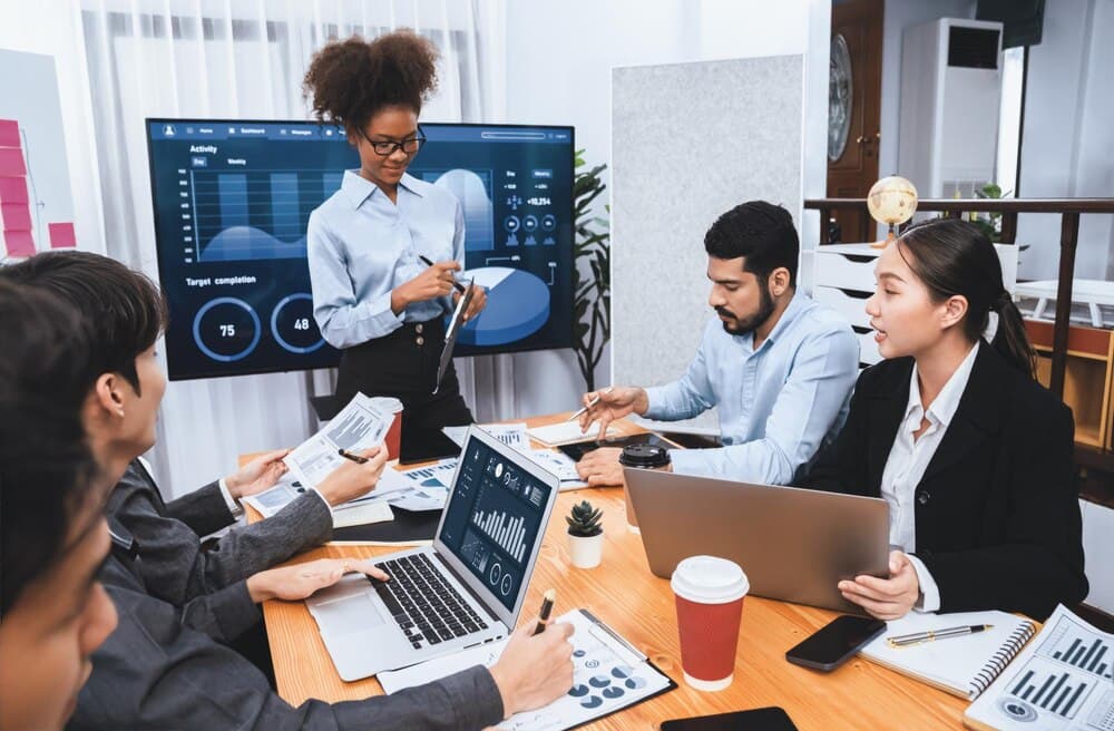 Executiva apresentando dashboard de análise de dados em tela corporativa